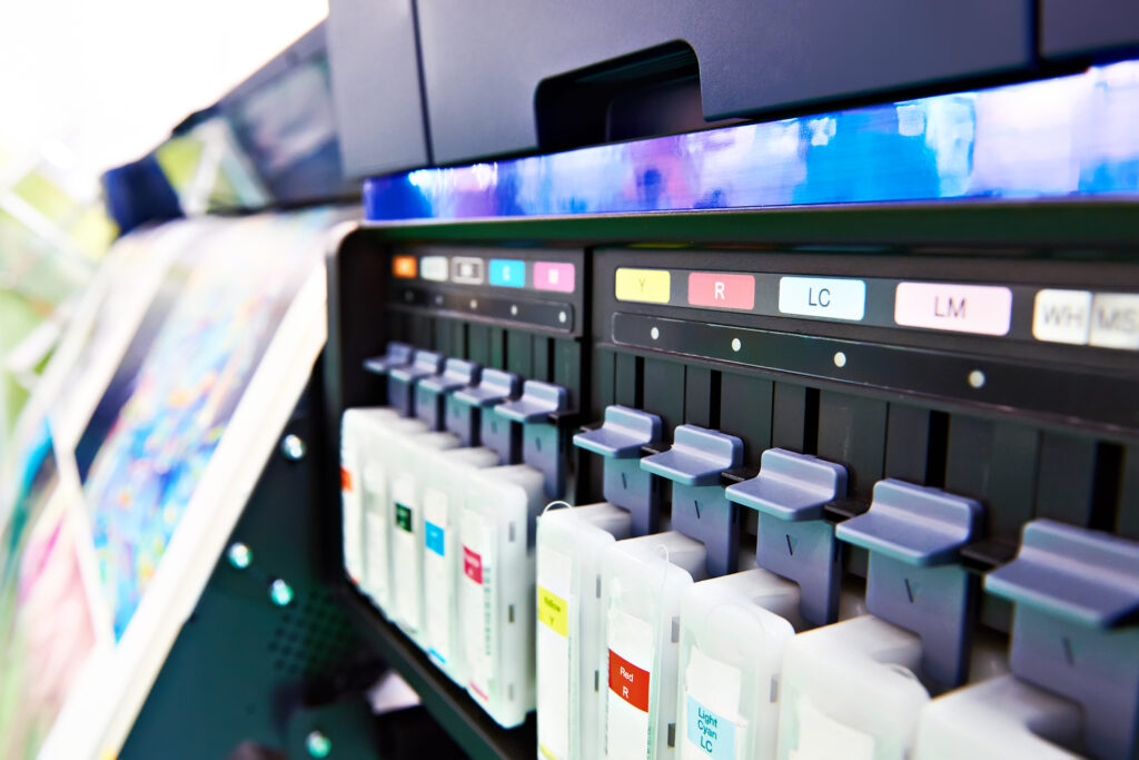 Close-up of ink cartridges inside a large-format printer used for full-color graphic printing.